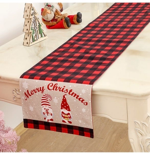 Detail of red and black buffalo check table runner with Merry Christmas gnome print
