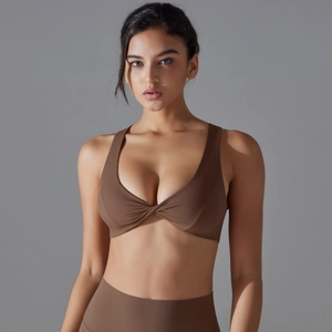Detail of V-neck twisted sports bra and high-waist yoga leggings in brown matte fabric