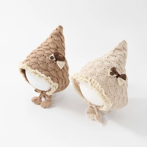 Cute pointed baby knitted hat with bow and lace trim in brown and beige colors