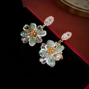 Luxury flower cluster crystal drop earrings with green accents on black jewelry box