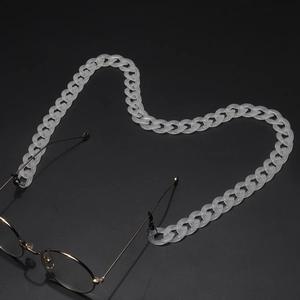 Close-up of translucent acrylic glasses chain links in a heart shape on a dark surface