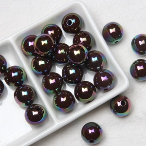 Detailed macro shot of iridescent AB coated round acrylic beads in a white ceramic dish