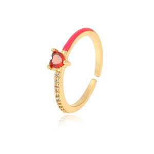 Close-up of golden adjustable heart ring with red gem, pink enamel and sparkling crystals