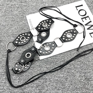 Detail of Y2K vintage black leather belt with silver rivets and metal O-ring design