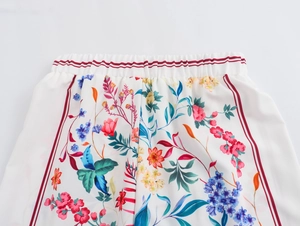 Macro view of floral print waistband on wide-leg trousers with red striped detail