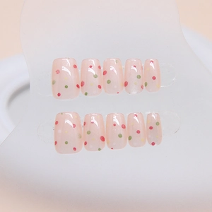 Handmade cat-eye press-on nails with colorful polka dots on a light pink base