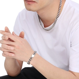 Polished silver stainless steel Cuban link necklace and bracelet set on a model
