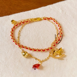 Vue détaillée du bracelet plaqué or 18k avec cordon rouge, cheval doré et cloches