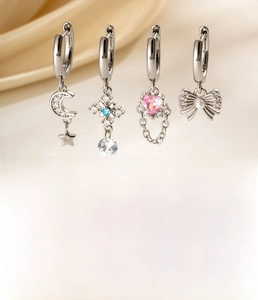 Silbernes Ohrring-Set mit Mond, Kreuz, Herz und Perlen-Schleifen-Anhängern auf Satin