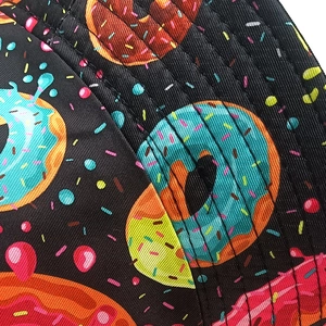 Gros plan sur la texture du tissu avec motif donuts colorés sur chapeau bob noir