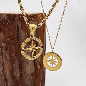 Gold stainless steel compass and north star pendant necklaces on wood block display