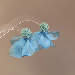 Detailed macro view of light blue organza flower petals and beaded clusters on earrings