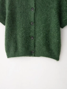 Dettaglio del cardigan in maglia mohair verde scuro con quattro bottoni neri vintage