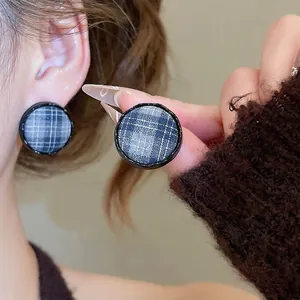 Minimalist blue and white plaid round stud earrings with fabric texture and black frames