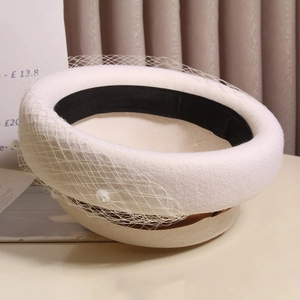 Detail of white wool pillbox hat with delicate mesh veil and internal black sweatband