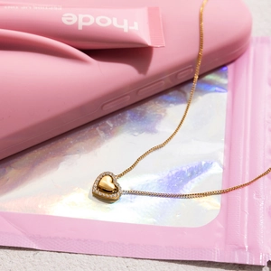 Detail of 18K gold-plated heart necklace with sparkling crystals and minimalist chain