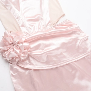 Close-up of pink satin dress showing 3D fabric flower detail and smooth silky texture
