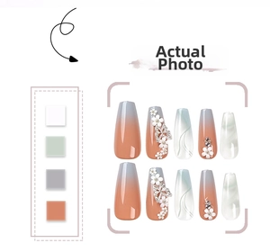 Detail of long ballerina press-on nails with gradient orange, floral relief and 3D butterfly