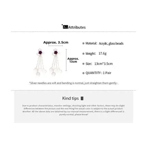 Detail of purple floral tassel earrings with acrylic beads and silver needles