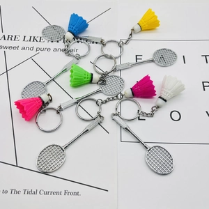 Detailed view of colorful mini badminton racket and shuttlecock keychains on white background