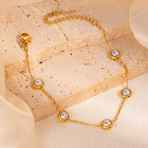Detailed macro view of the gold-plated chain with grey pearls and adjustable lobster clasp