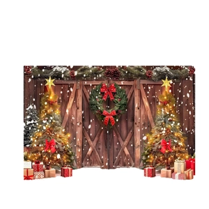 Rustic Christmas backdrop featuring barn doors with festive wreaths and glowing trees