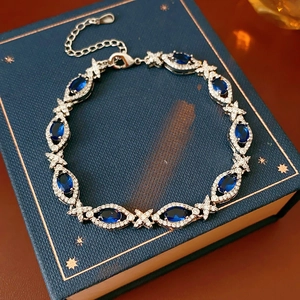 Macro detail of vintage silver bracelet with oval blue stones and zircons on a book
