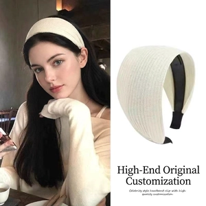Detail view of cream white knitted headband with striped texture and black non-slip inner grip