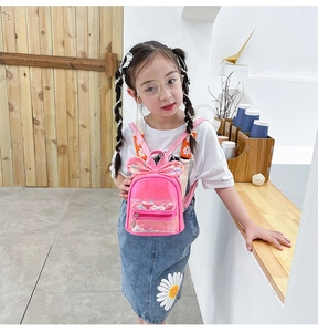 Close-up of pink children backpack with rabbit ears, transparent sequin pocket and floral straps