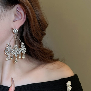 Gros plan de boucles d'oreilles à fleurs et glands en cristal sur un mannequin