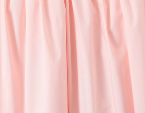 Detail view of light pink pleated fabric showing delicate texture and woven craftsmanship
