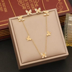 Parure de bijoux papillon dorés avec collier et boucles d'oreilles sur velours