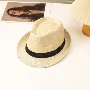 Detail showing the woven texture and black ribbon band of a beige straw fedora hat
