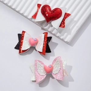 Three glittery bow hair clips with heart and wing details for Valentine's Day styling