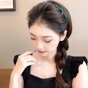 Elegant green braided fabric headband worn by a model for a stylish high skull top look