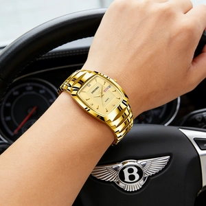 Luxe goudkleurig horloge met dag-datumweergave bij het stuur van een exclusieve auto
