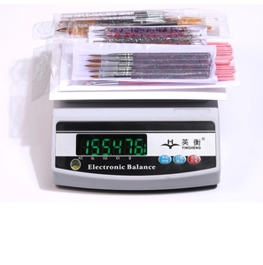 Detailed view of nail art brush set being weighed on an electronic scale at 155.476g