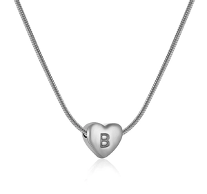 Dettaglio ravvicinato di un ciondolo a cuore argento inciso con la lettera B su catena