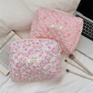 Detailed view of quilted makeup bags with floral and bunny prints on soft fabric