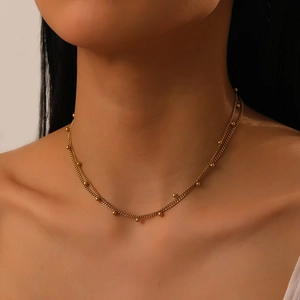 Vue rapprochée du collier double rang en acier inoxydable doré orné de perles