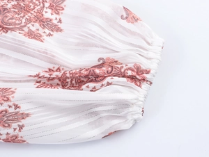 Dettaglio del polsino in chiffon bianco con stampa paisley rosa ed elastico