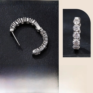 Macro detail of sparkling moissanite stones set in a polished S925 sterling silver C-hoop earring