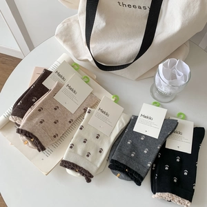 Gros plan de cinq paires de chaussettes en coton vintage brodées de fleurs en divers coloris
