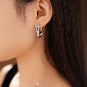 Macro shot of double layered silver earrings with zircon stones worn by a model