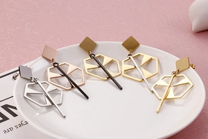 Detailed macro view of geometric hollow earrings in silver, rose gold and gold finishes