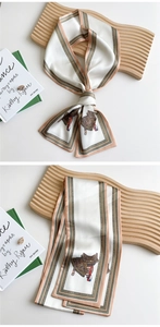 Macro detail of silk-like neckerchief with equestrian print and golden-brown stripes