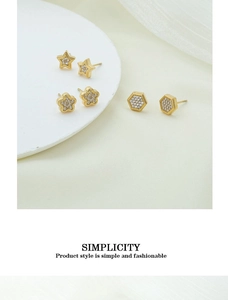 Detailed view of gold plated star and flower stud earrings set with white zircon stones
