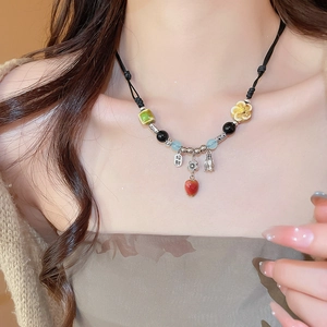 Detail of handcrafted ceramic beads and Zhaocai charm on a vintage ethnic necklace