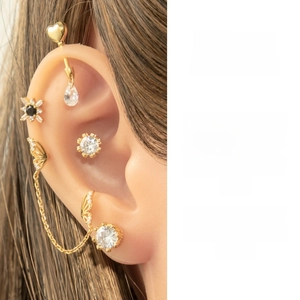 Detail of gold butterfly ear cuff set with rhinestones and chain on model ear