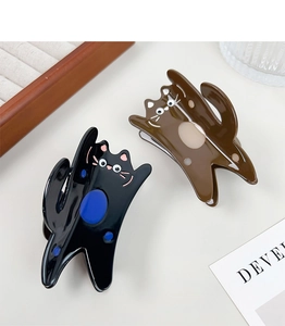 Detail of cute acetate cat hair claws in black and brown with glossy spotted patterns